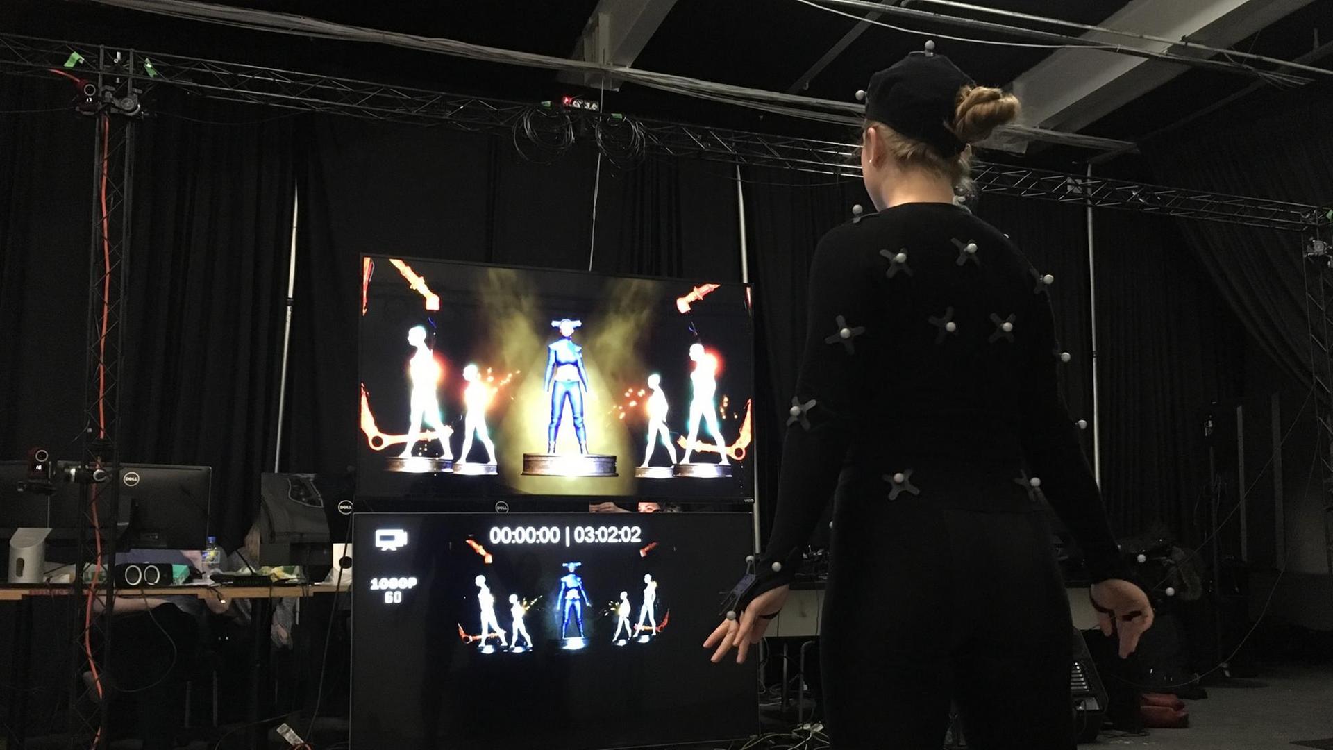 Eine Tänzerin mit unzähligen Sensoren an der Kleidung bringt das Hologramm Maya Kodes zum Tanzen. Eine Tänzerin mit unzähligen Sensoren an der Kleidung bringt das Hologramm Maya Kodes zum Tanzen.