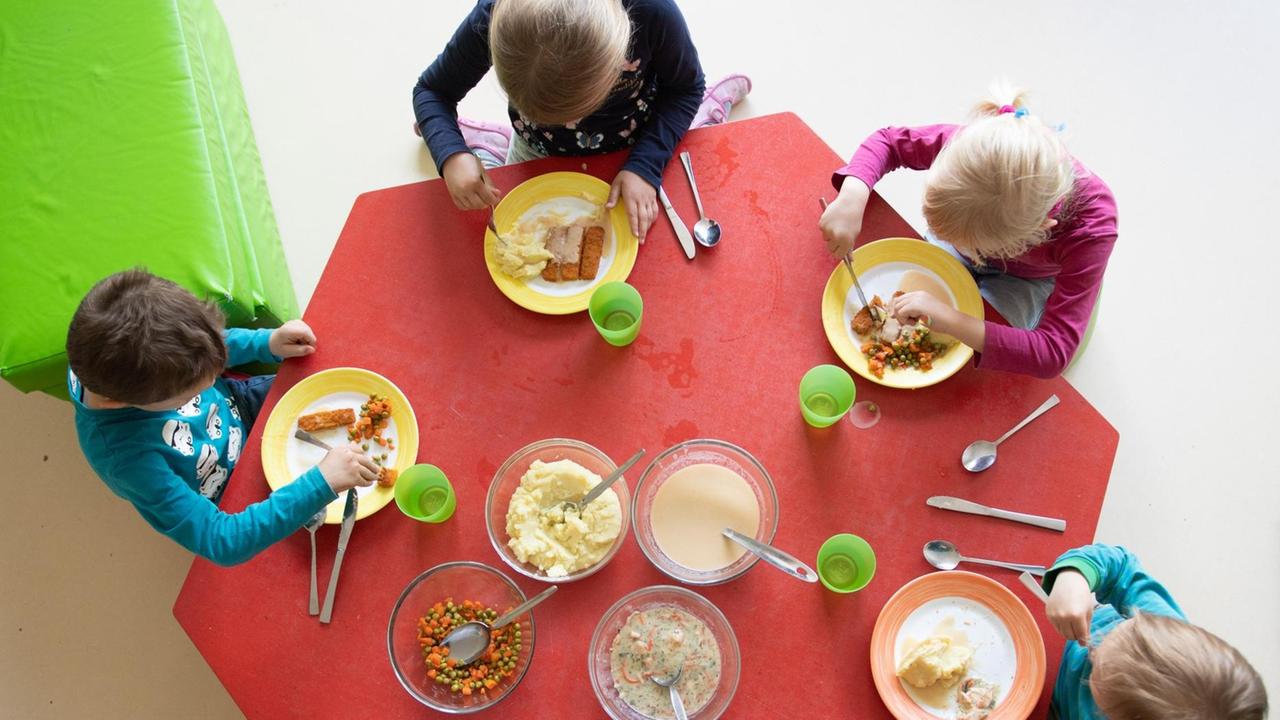Kinder sitzen im Rahmen der Notbetreuung in einem Kindergarten in Sachsen während des Mittagessens an einem Tisch. Kinder sitzen im Rahmen der Notbetreuung in einem Kindergarten in Sachsen während des Mittagessens an einem Tisch.