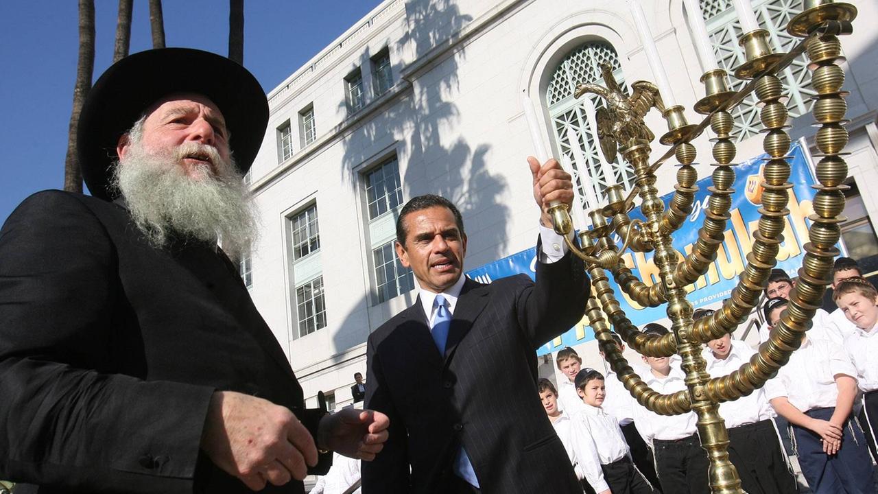Ein Bürgermeister und ein Rabbi präparieren die Kerzen auf einem Menoarah während der Chabad Chanukka-Feier in den USA. Ein Bürgermeister und ein Rabbi präparieren die Kerzen auf einem Menoarah während der Chabad Chanukka-Feier in den USA.