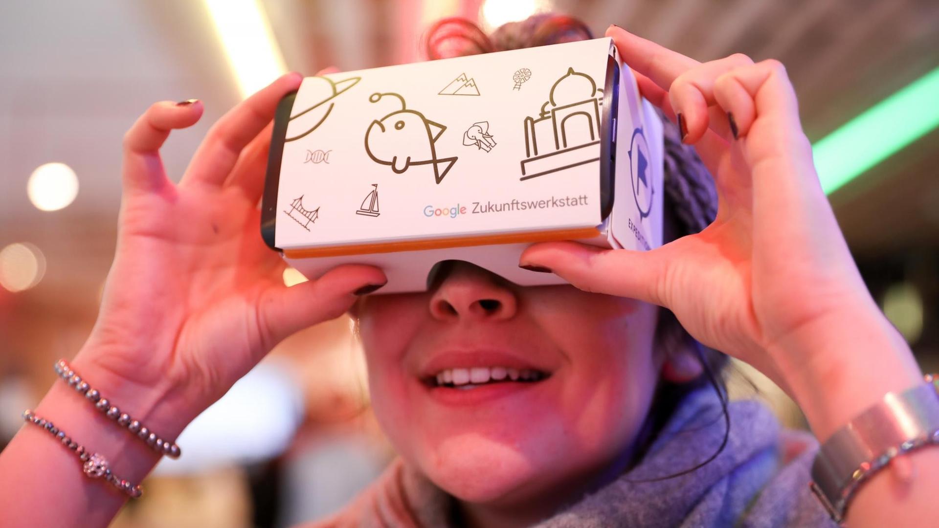 20.03.2018, Hamburg: Eine junge Frau schaut vor einer Pressekonferenz zur Google Zukunftswerkstatt Hamburg in eine VR-Brille von Google. Lehrer und Schüler, Berufstätige und Gründer sollen bei Google in Hamburg fitter für die Codes und Digitalisierung von Morgen werden. 20.03.2018, Hamburg: Eine junge Frau schaut vor einer Pressekonferenz zur Google Zukunftswerkstatt Hamburg in eine VR-Brille von Google. Lehrer und Schüler, Berufstätige und Gründer sollen bei Google in Hamburg fitter für die Codes und Digitalisierung von Morgen werden.