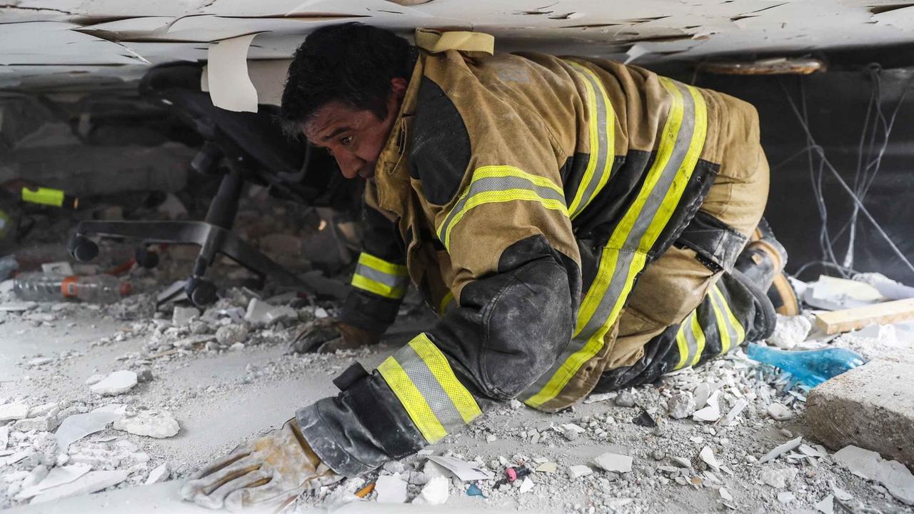 Ein Feuerwehrmann sucht in Mexiko-Stadt in einem zerstörten Gebäude nach Überlebenden des Erdbebens.