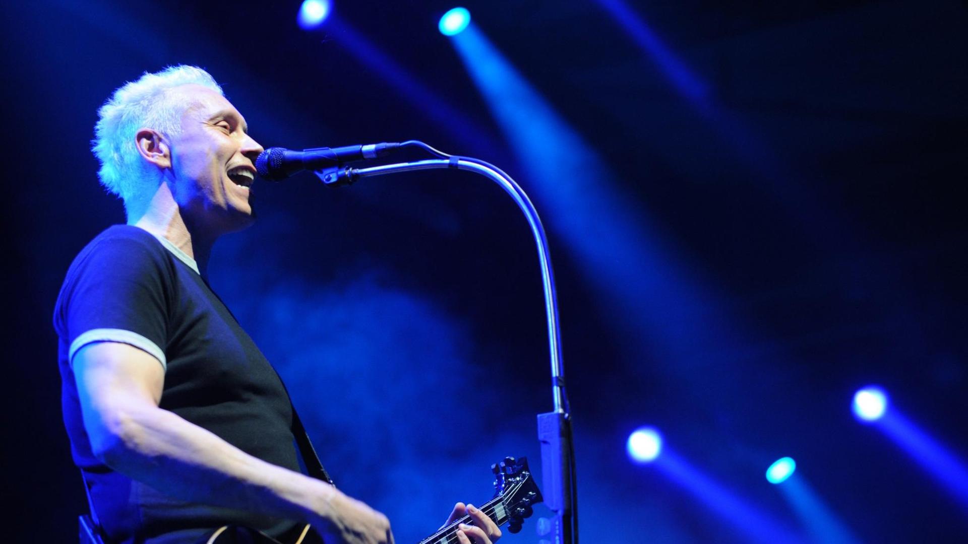 Ein Mann mit hellblonden Haaren steht im blauen Scheinwerferlicht auf einer Bühne. Er spielt Gitarre und singt. Es ist Farin Urlaub von der Band Die Ärzte. Ein Mann mit hellblonden Haaren steht im blauen Scheinwerferlicht auf einer Bühne. Er spielt Gitarre und singt. Es ist Farin Urlaub von der Band Die Ärzte.