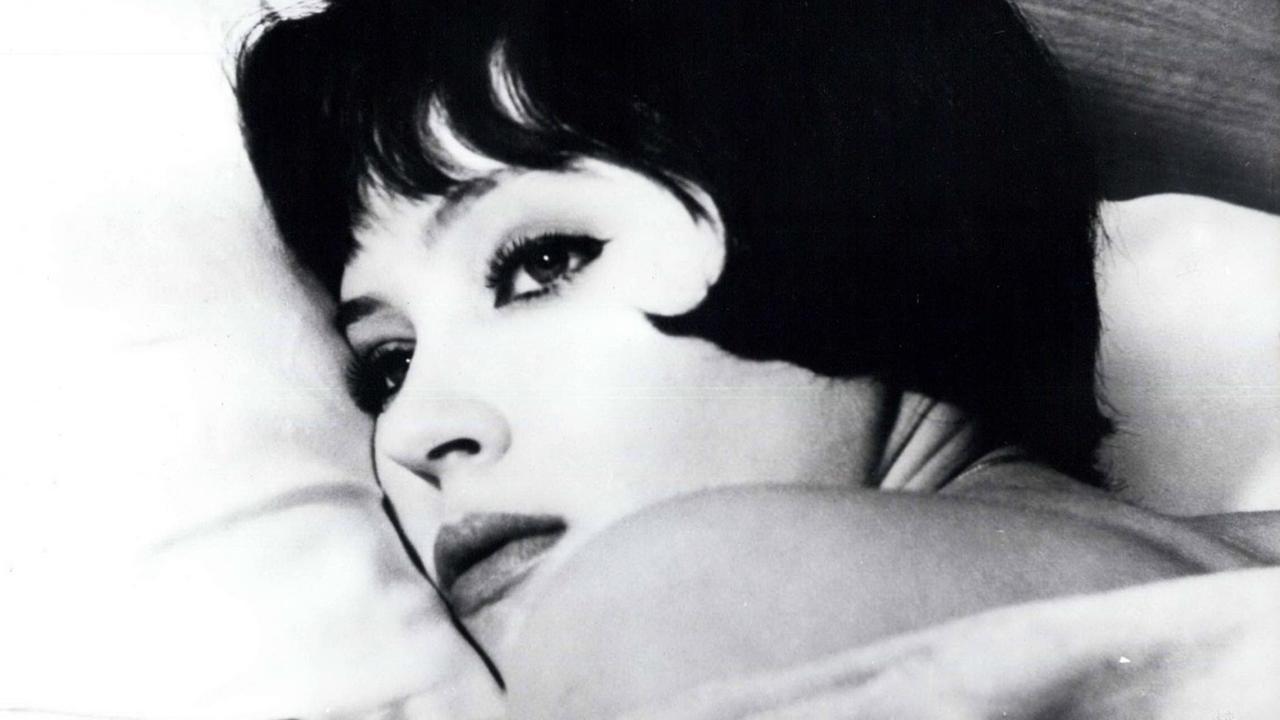 Eine Filmszene aus "Die Geschichte der Nana S." von Jean Luc Godard zeigt Anna Karina in einer Nahaufnahme auf einem weißen Kissen liegend. Eine Filmszene aus "Die Geschichte der Nana S." von Jean Luc Godard zeigt Anna Karina in einer Nahaufnahme auf einem weißen Kissen liegend.