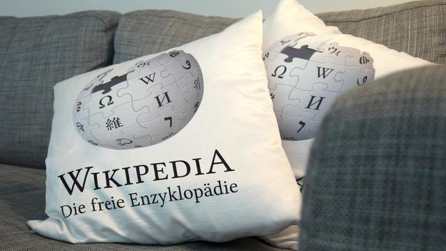 Kissen mit "Wikipedia"-Schriftzug auf einem grauen Sofa in den Räumen von Wikimedia Deutschland in Berlin