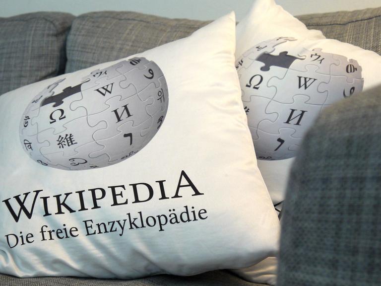Kissen mit "Wikipedia"-Schriftzug auf einem grauen Sofa in den Räumen von Wikimedia Deutschland in Berlin