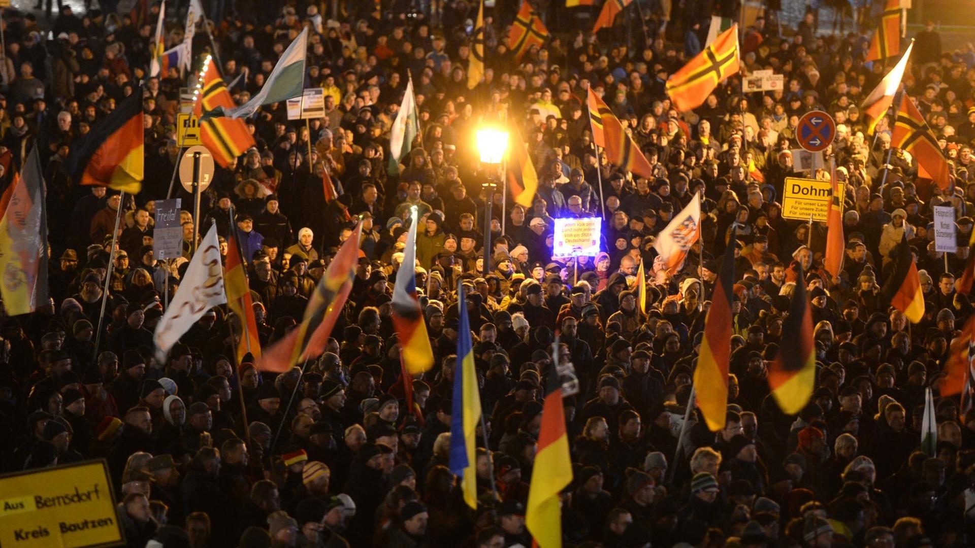Teilnehmer haben sich am 23.11.2015 auf dem Theaterplatz in Dresden (Sachsen) während einer Kundgebung des Bündnisses Pegida (Patriotische Europäer gegen die Islamisierung des Abendlandes) versammelt. Teilnehmer haben sich am 23.11.2015 auf dem Theaterplatz in Dresden (Sachsen) während einer Kundgebung des Bündnisses Pegida (Patriotische Europäer gegen die Islamisierung des Abendlandes) versammelt.