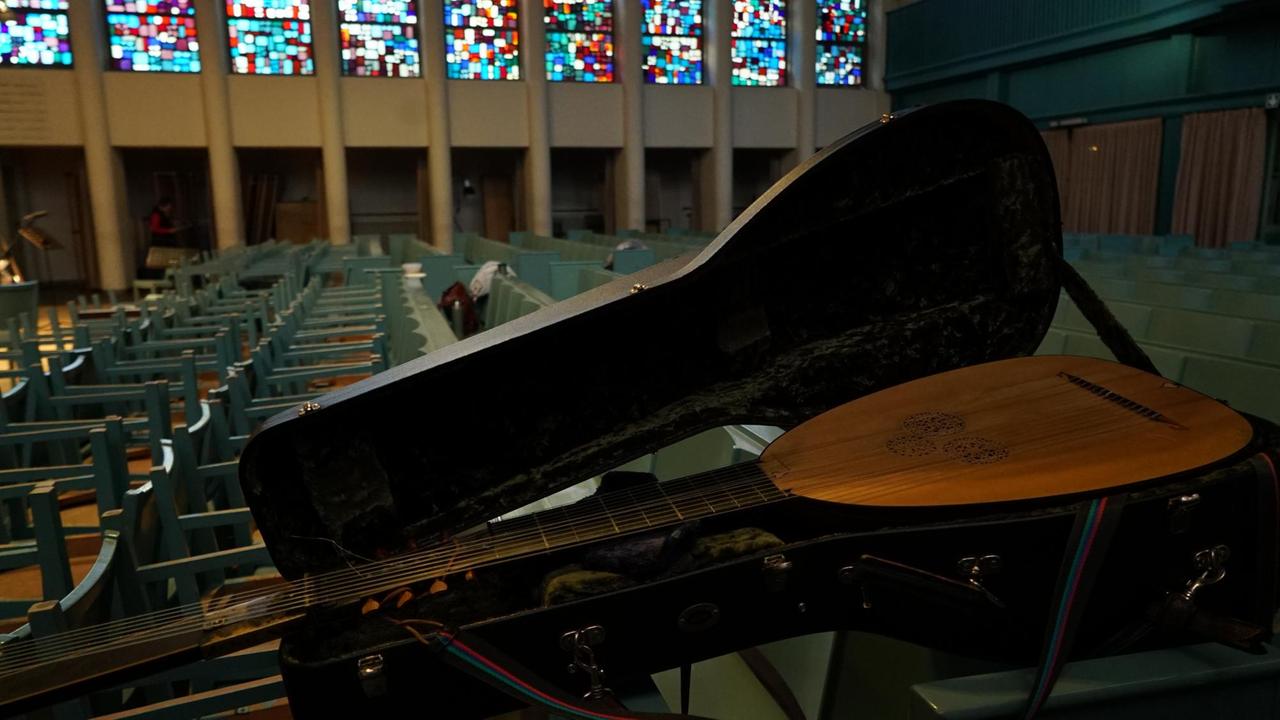 Das Lauteninstrument liegt in einem Kasten, der auf den leeren Kirchenbänken ruht. Das Lauteninstrument liegt in einem Kasten, der auf den leeren Kirchenbänken ruht.
