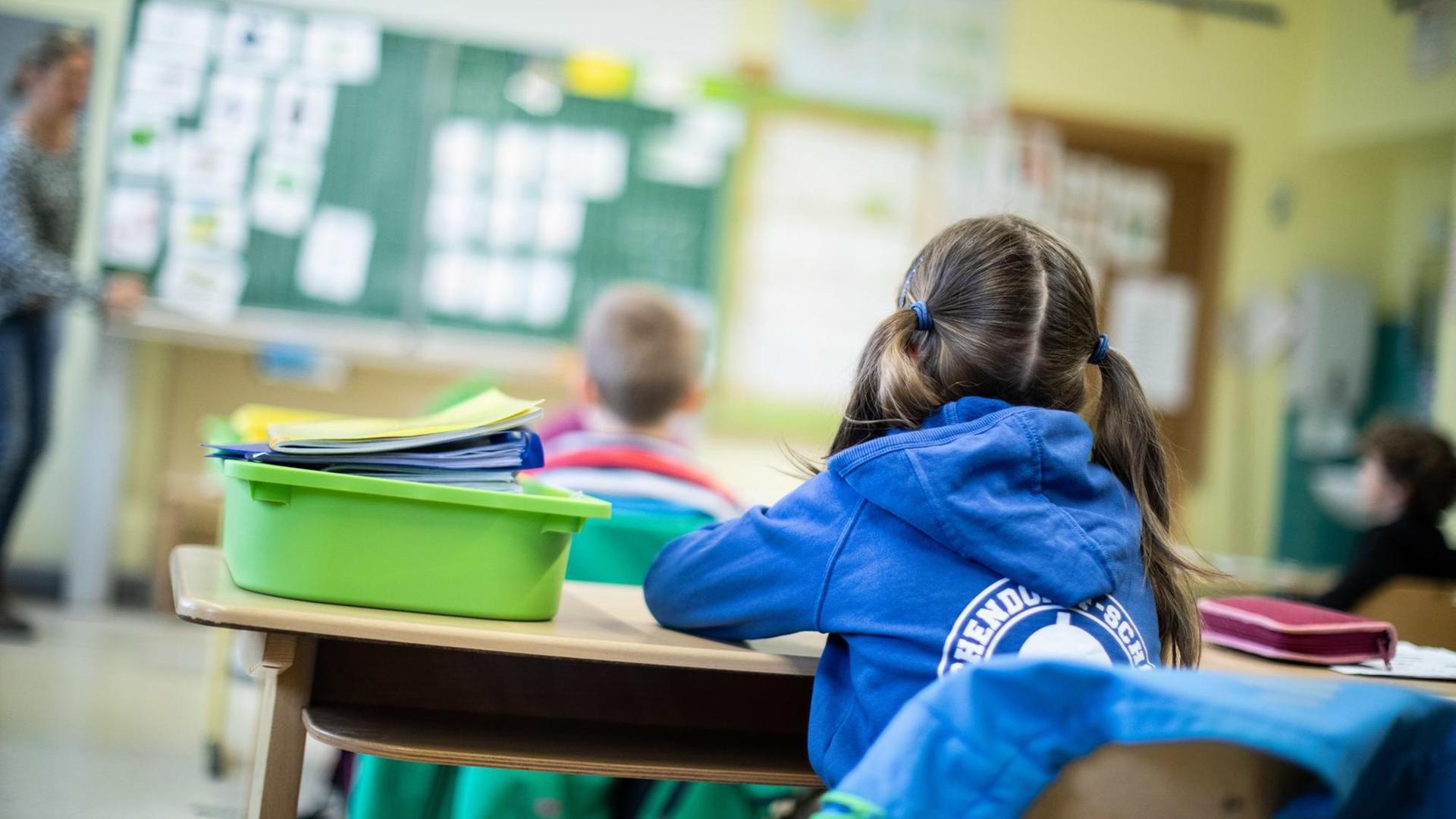Schülerinnen und Schüler aus der 1. Klasse sitzen im Klassen-Raum Schülerinnen und Schüler aus der 1. Klasse sitzen im Klassen-Raum