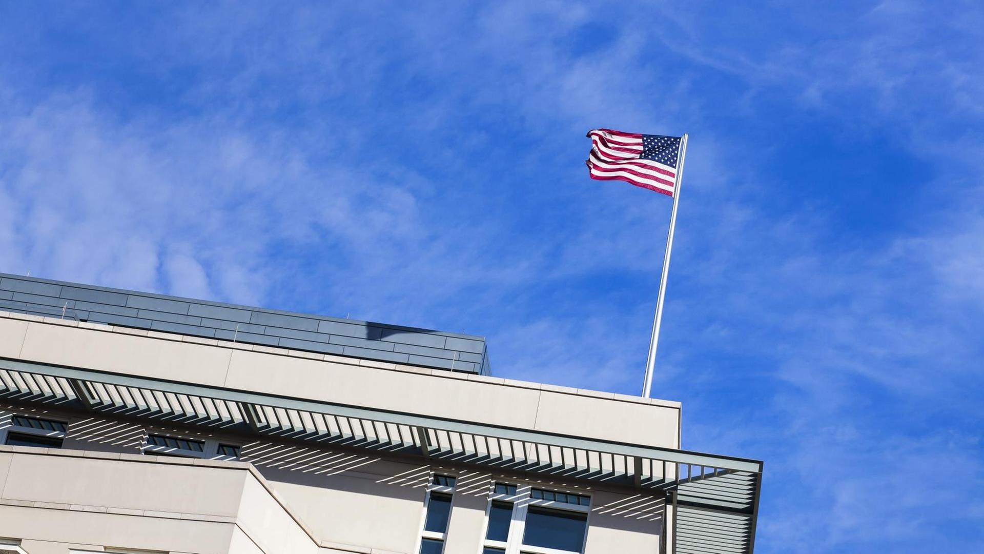 Auf einem Gebäude ist eine USA-Fahne, die im Wind weht. Auf einem Gebäude ist eine USA-Fahne, die im Wind weht.