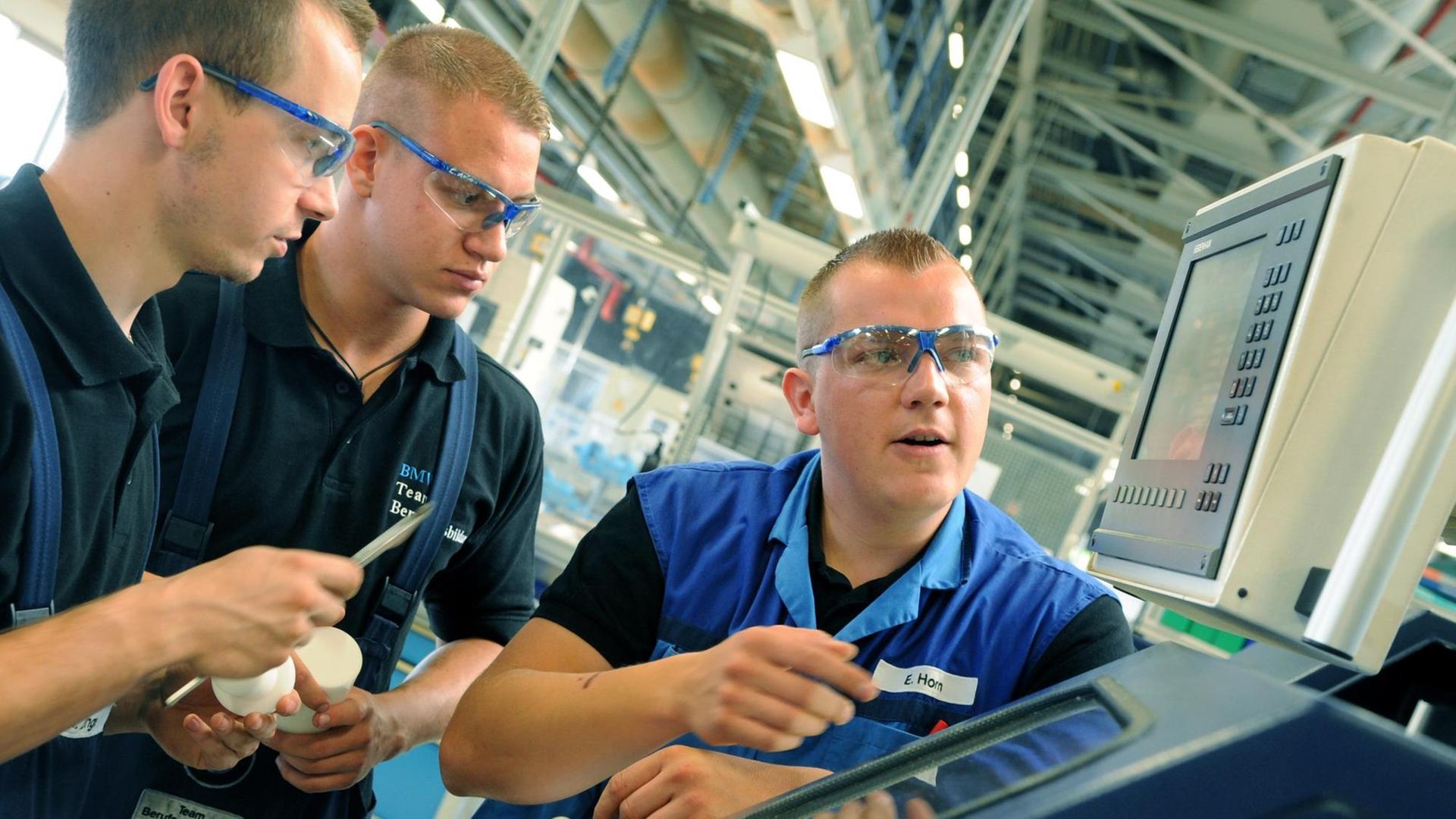 Im BMW-Werk in Leipzig erklärt der Ausbilder für Industrie-und Fertigungsmechaniker Enrico Horn (r) den angehenden Fertigungsmechanikern Henry Lange (l) und Chris Themel an einer CNC-Drehmaschine die Fertigung von Kunsthülsen. Im BMW-Werk in Leipzig erklärt der Ausbilder für Industrie-und Fertigungsmechaniker Enrico Horn (r) den angehenden Fertigungsmechanikern Henry Lange (l) und Chris Themel an einer CNC-Drehmaschine die Fertigung von Kunsthülsen.