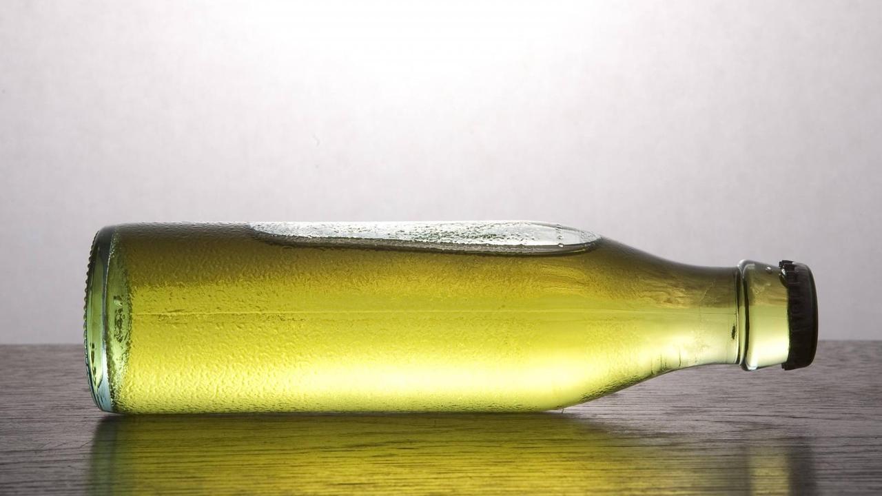 Eine Flasche mit grünem Inhalt liegt auf der Seite Eine Flasche mit grünem Inhalt liegt auf der Seite