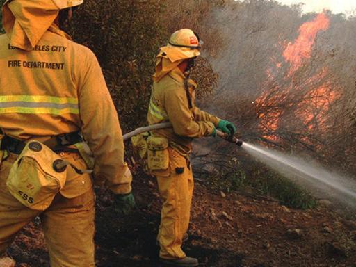 Zwei Feuerwehrmänner bekämpfen den Waldbrand in Kalifornien.