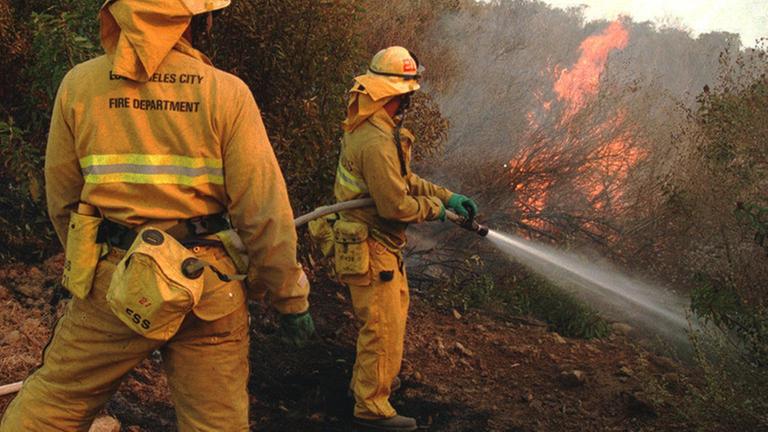 Zwei Feuerwehrmänner bekämpfen den Waldbrand in Kalifornien. Zwei Feuerwehrmänner bekämpfen den Waldbrand in Kalifornien.