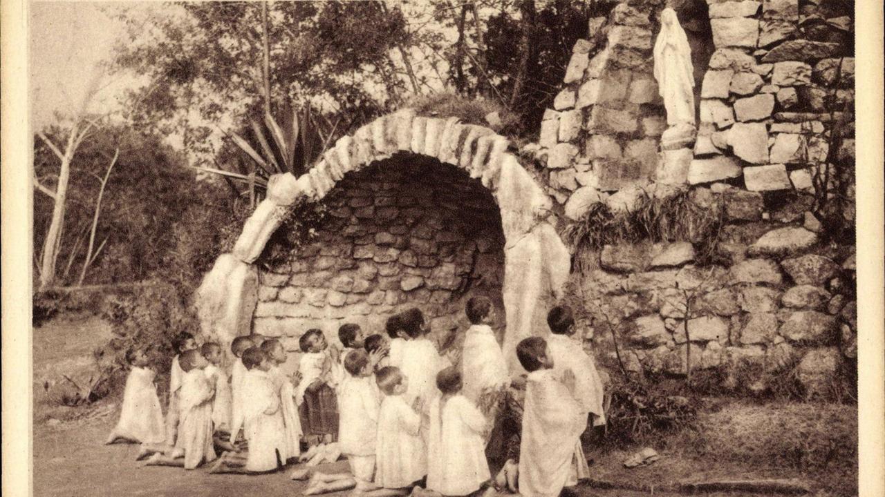 Madagaskar, Kinder auf den Knien vor der hl. Lourdes Madagaskar, Kinder auf den Knien vor der hl. Lourdes