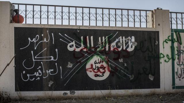 Neben das auf eine Wand aufgemalte und durchgestrichene Emblem der Terrororganisation "Islamischer Staat" hat jemand die Worte "Sieg für alle Iraker" geschrieben