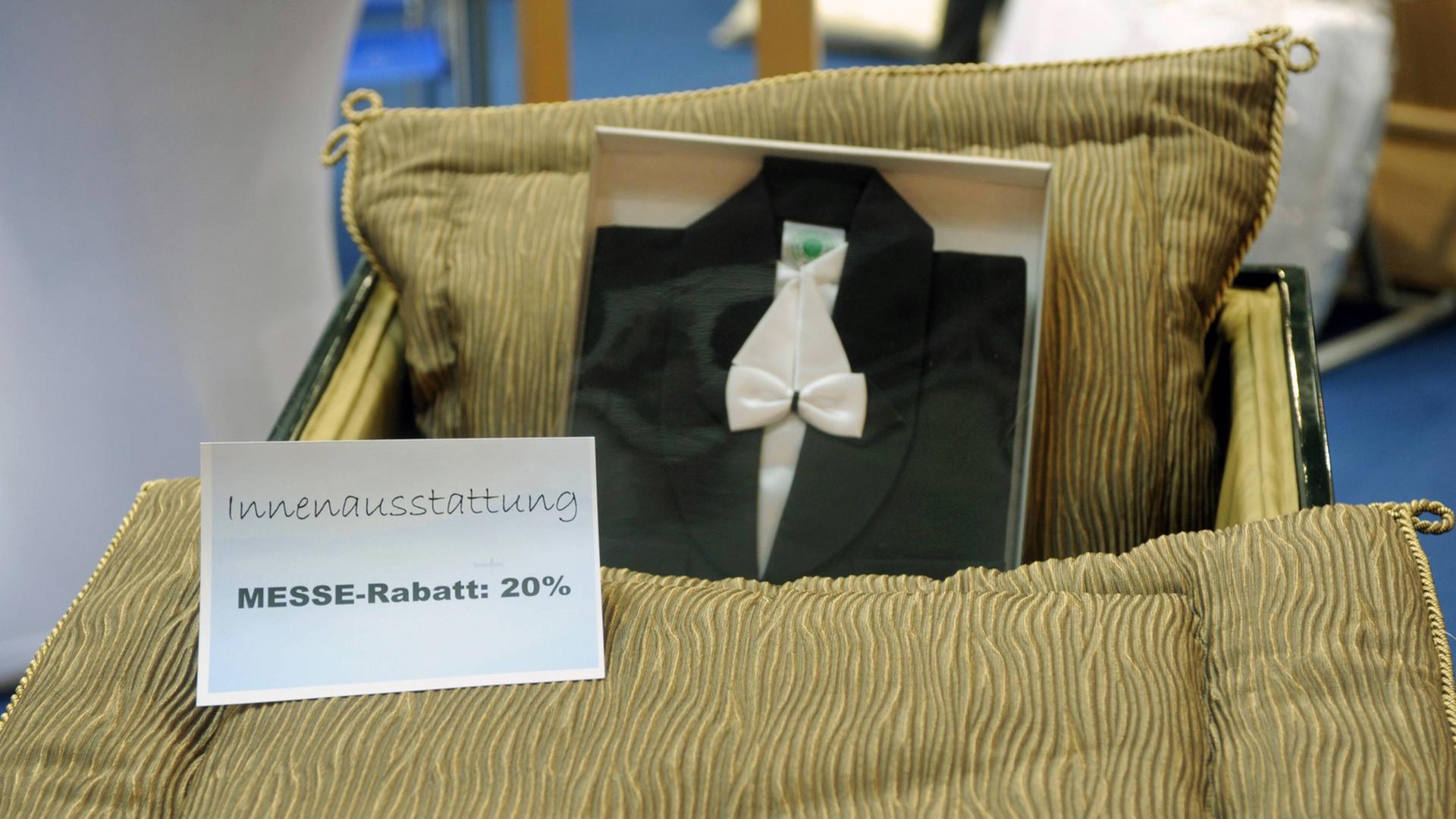 Innenausstattung eines Sargs mit dem Schild "20 Prozent Messerabatt" auf der BEFA, der weltgrößten Bestatterfachmesse mit Produkten rund um Bestattung, Friedhof und Grabpflege Innenausstattung eines Sargs mit dem Schild "20 Prozent Messerabatt" auf der BEFA, der weltgrößten Bestatterfachmesse mit Produkten rund um Bestattung, Friedhof und Grabpflege