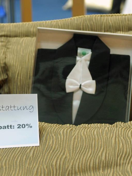 Innenausstattung eines Sargs mit dem Schild "20 Prozent Messerabatt" auf der BEFA, der weltgrößten Bestatterfachmesse mit Produkten rund um Bestattung, Friedhof und Grabpflege