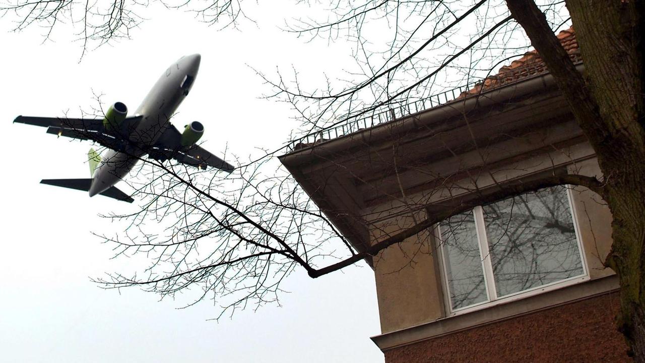 Ein Flugzeug fliegt dicht über ein Wohnhaus in Berlin-Tegel.