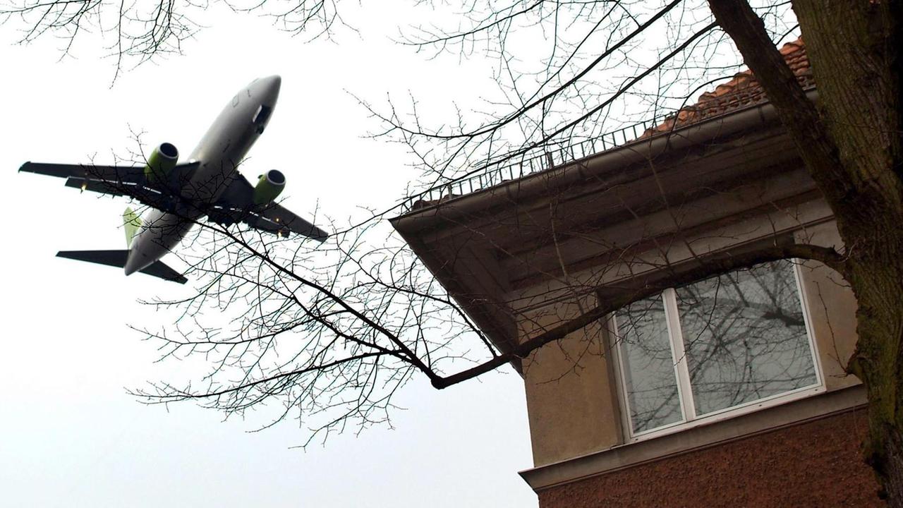 Ein Flugzeug fliegt dicht über ein Wohnhaus in Berlin-Tegel. Ein Flugzeug fliegt dicht über ein Wohnhaus in Berlin-Tegel.