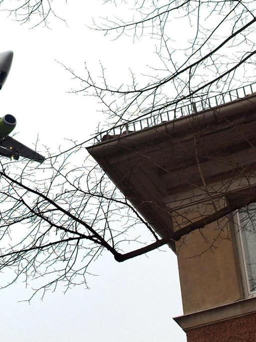 Ein Flugzeug fliegt dicht über ein Wohnhaus in Berlin-Tegel.