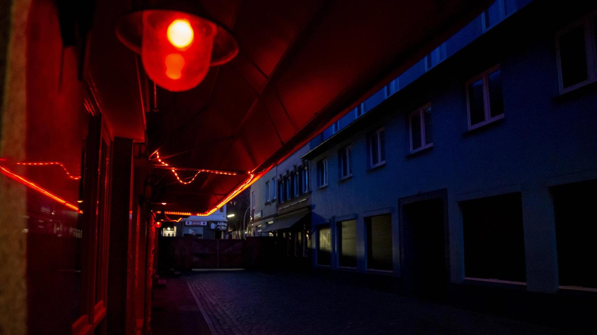 Blick in die leere Herbertstraße bei Nacht. Nur eine rote Laterne leuchtet in der dunklen Straße. Blick in die leere Herbertstraße bei Nacht. Nur eine rote Laterne leuchtet in der dunklen Straße.