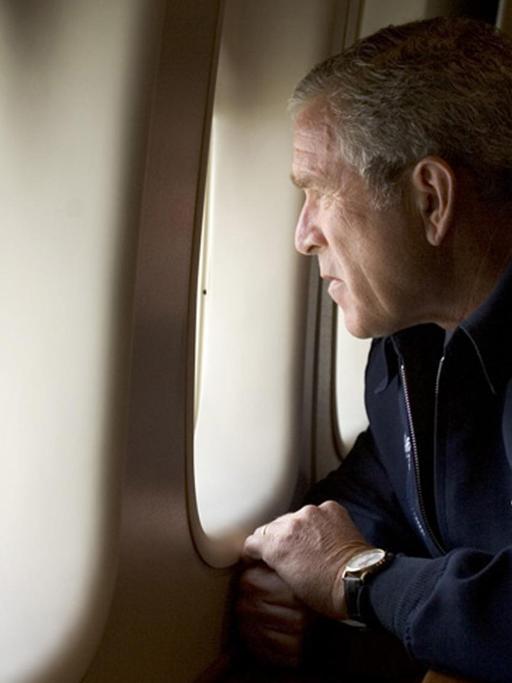 US-Präsidenten George W. Bush schaut aus den Flugzeugfenstern der Air Force One nach draußen. 