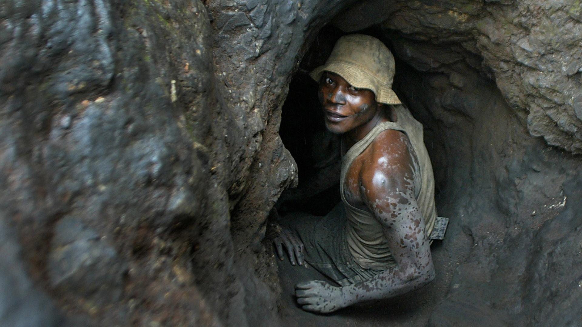 Im Kongo klettert ein Mann in eine enge Mine um Kobalt abzubauen Im Kongo klettert ein Mann in eine enge Mine um Kobalt abzubauen