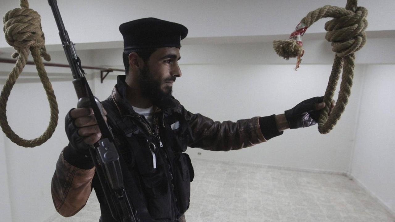 Ein Rebellenkämpfer der Freien Syrischen Armee inspiziert 2013 einen Hinrichtungsraum in Darkusch, Provinz Idlib Ein Rebellenkämpfer der Freien Syrischen Armee inspiziert 2013 einen Hinrichtungsraum in Darkusch, Provinz Idlib