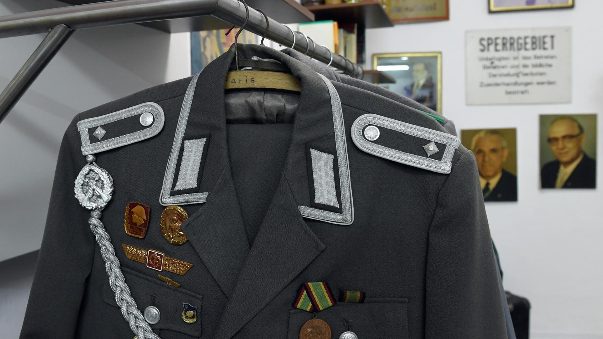 Die Uniformjacke eines Feldwebels der NVA hängt am 12.07.2016 in der Ausstellung des NOstalgiemuseums in Leipzig (Sachsen). Mehr als 30.000 Exponate erinern in der Ausstellung, die am Samstag (16.07.2016) eröffnet wird, an 40 Jahre Alltag in der DDR. Der Großvater der heutigen Museumschefin hatte die Utensilien einst zusammengetragen und das Museum bereits 1999 in Brandenburg an der Havel eröffnet - jetzt ist es in die Messestadt umgezogen. Foto: Hendrik Schmidt/ZB | Verwendung weltweit Die Uniformjacke eines Feldwebels der NVA hängt am 12.07.2016 in der Ausstellung des NOstalgiemuseums in Leipzig (Sachsen). Mehr als 30.000 Exponate erinern in der Ausstellung, die am Samstag (16.07.2016) eröffnet wird, an 40 Jahre Alltag in der DDR. Der Großvater der heutigen Museumschefin hatte die Utensilien einst zusammengetragen und das Museum bereits 1999 in Brandenburg an der Havel eröffnet - jetzt ist es in die Messestadt umgezogen. Foto: Hendrik Schmidt/ZB | Verwendung weltweit