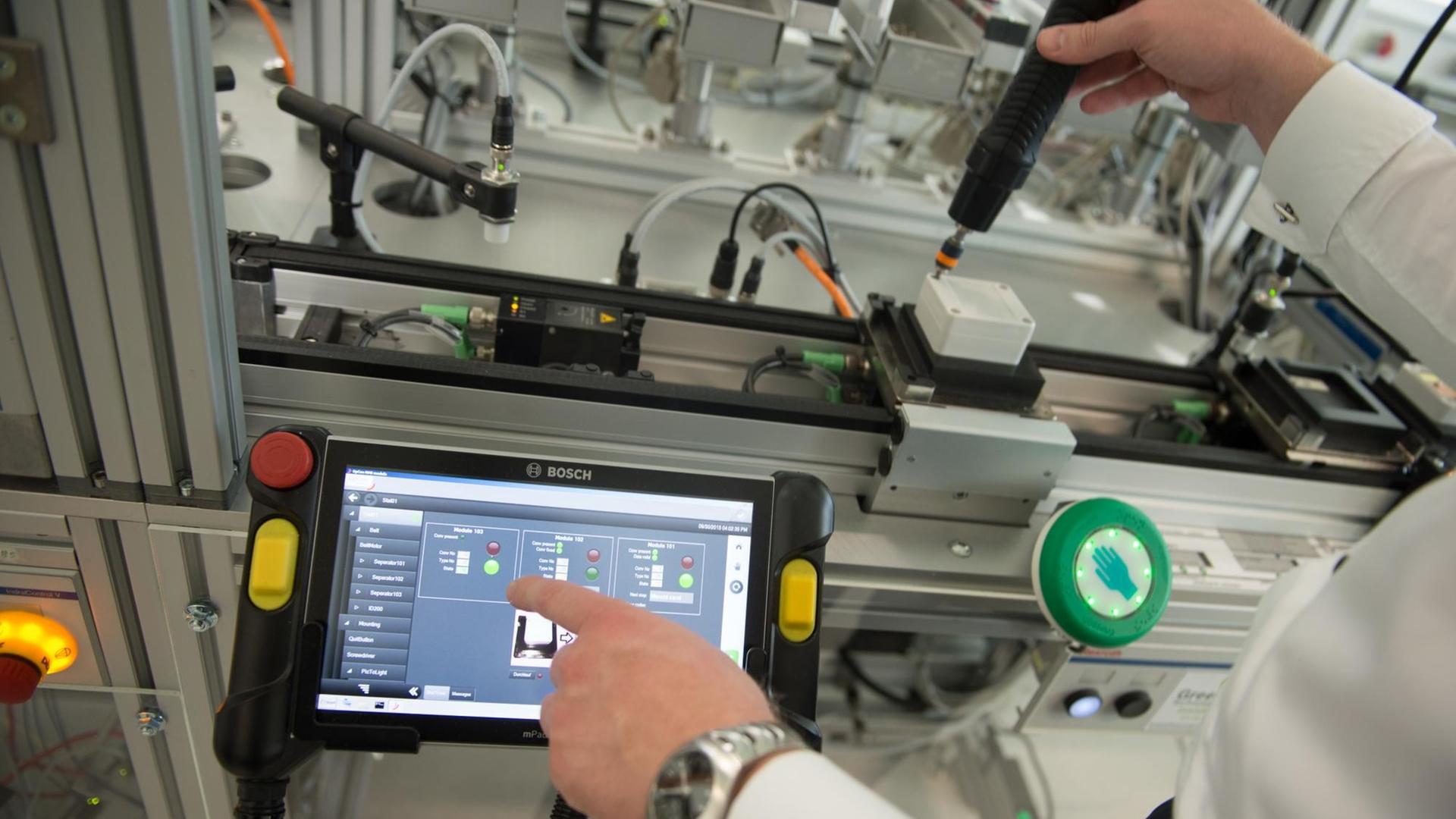 Ein Bosch-Mitarbeiter bedient im Zentralbereich Forschung und Vorausentwicklung der Robert Bosch GmbH in Renningen im Rahmen eines Pressetermins eine Industrie 4.0-Erprobungsanlage.