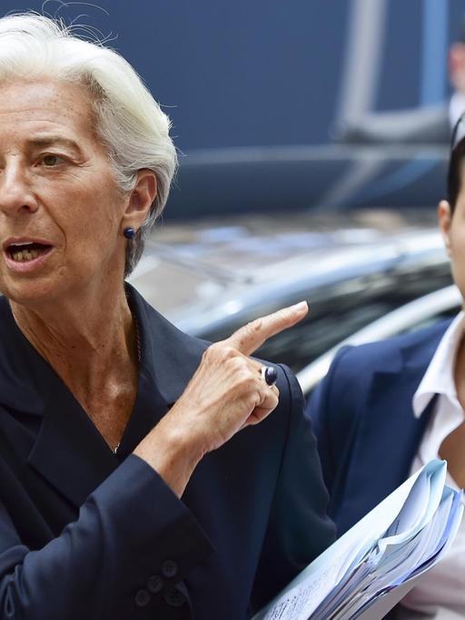IWF-Chefin Christine Lagarde deutet mit dem Zeigefinger hinter sich