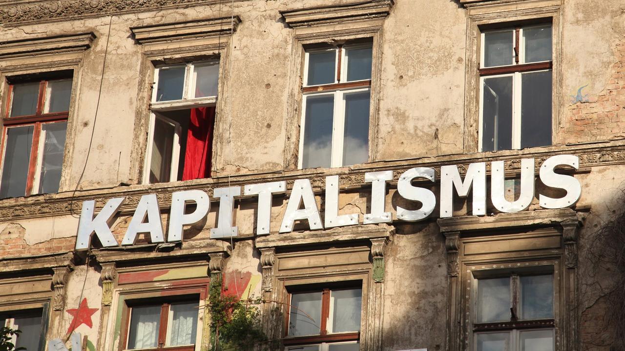 "Kapitalismus" steht auf einer Wand an einem besetzten Haus in einer Straße in Berlin im Stadtteil Prenzlauer Berg , aufgenommen am 11. August 2012.