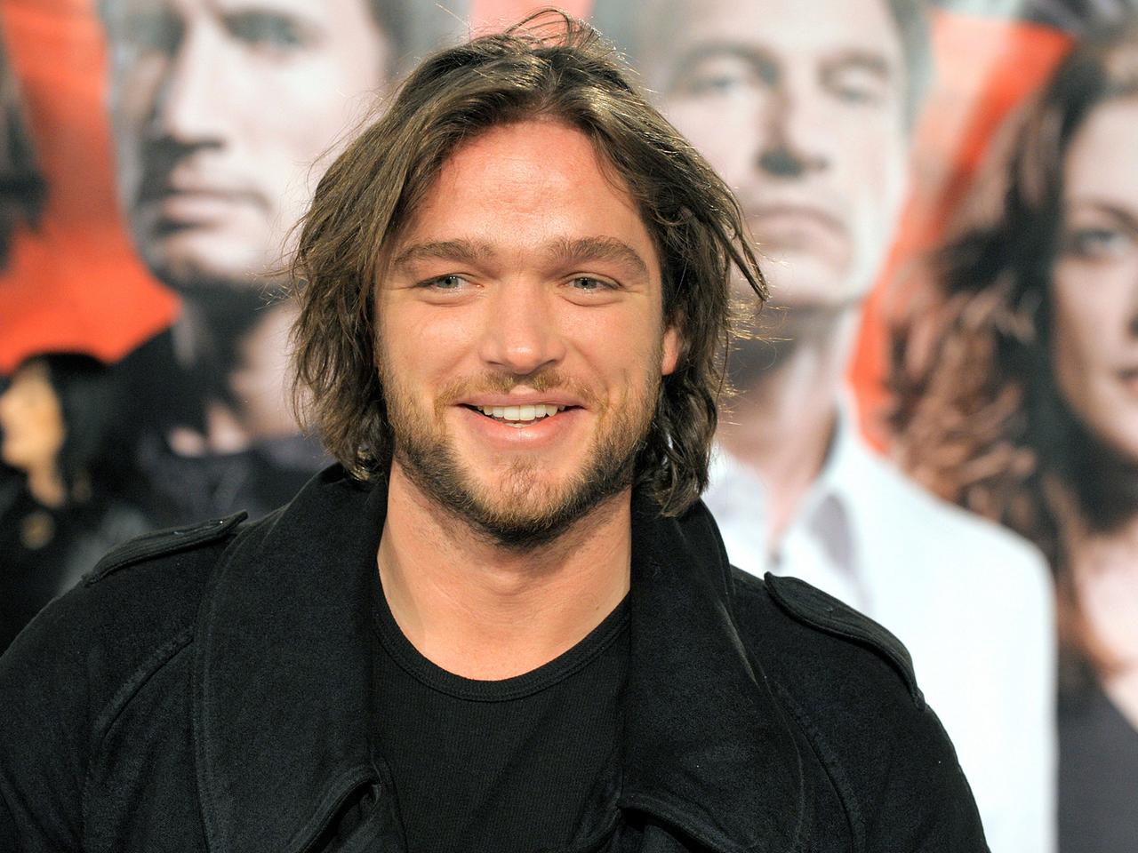 Der Schauspieler Ronald Zehrfeld steht auf der Premiere des Fernsehfilms "Die Grenze" vor einem Filmplakat. Der Schauspieler Ronald Zehrfeld steht auf der Premiere des Fernsehfilms "Die Grenze" vor einem Filmplakat.
