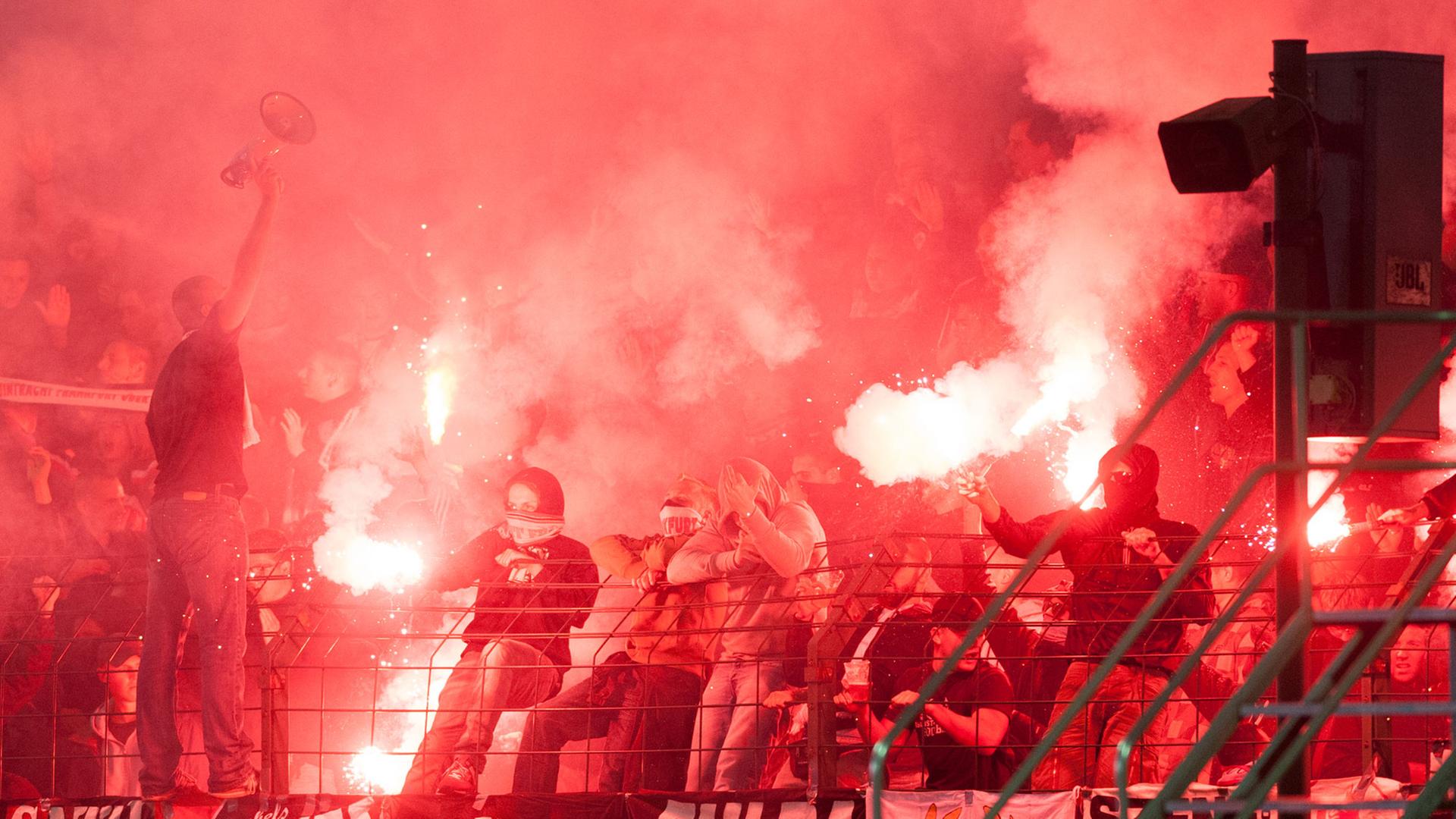Im Fußball-DFB-Pokale-Spiel zwischen Viktoria 1889 Berlin und Eintracht Frankfurt am 16.08.2014 in Berlin zünden Frankfurt-Fans Bengalos und Feuerwerkskörper vor Anpfiff der zweiten Halbzeit. Im Fußball-DFB-Pokale-Spiel zwischen Viktoria 1889 Berlin und Eintracht Frankfurt am 16.08.2014 in Berlin zünden Frankfurt-Fans Bengalos und Feuerwerkskörper vor Anpfiff der zweiten Halbzeit.