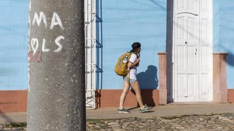Eine Frau läuft durch die Straßen der kubanischen Stadt Trinidad.