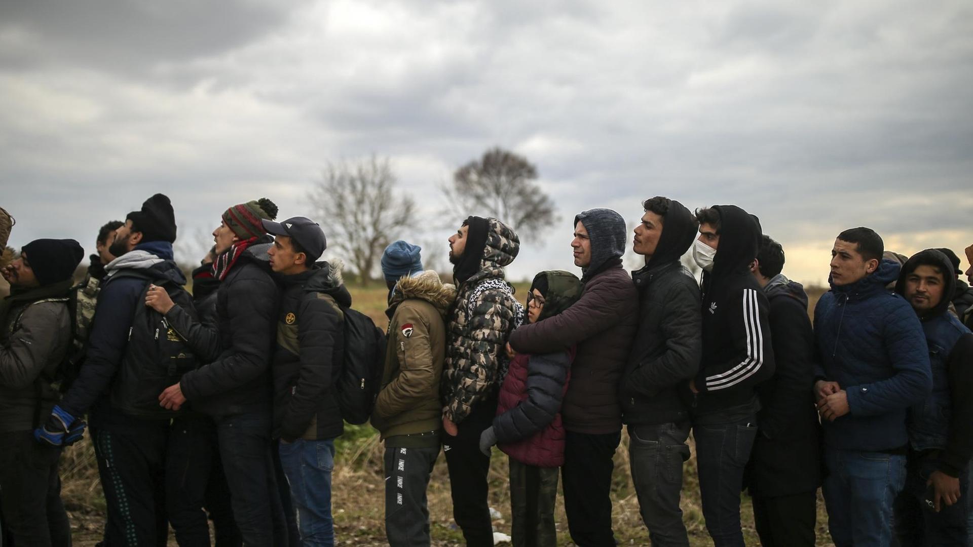 Flüchtlinge harren hinter einem Stacheldrahtzaun an der griechisch-türkischen Grenze aus Flüchtlinge harren hinter einem Stacheldrahtzaun an der griechisch-türkischen Grenze aus