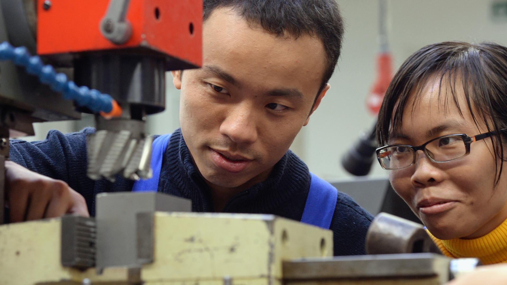 Zwei vietnamesische Arbeiter bei ihrer Ausbildung zu Mechatronikern in Chemnitz - Deutschland bleibt bei Zuwanderern beliebt. Zwei vietnamesische Arbeiter bei ihrer Ausbildung zu Mechatronikern in Chemnitz - Deutschland bleibt bei Zuwanderern beliebt.