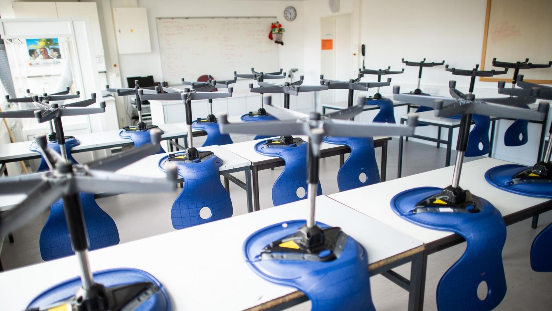 Stühle stehen in einem leeren Klassenzimmer im Carolus-Magnus-Gymnasium auf den Tischen. Stühle stehen in einem leeren Klassenzimmer im Carolus-Magnus-Gymnasium auf den Tischen.