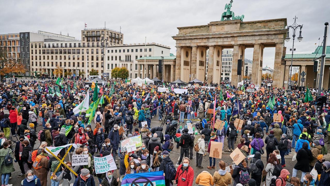 Berlin: Tausende Protestierende stehen mit Transparenten vor dem Brandenburger Tor. Berlin: Tausende Protestierende stehen mit Transparenten vor dem Brandenburger Tor.
