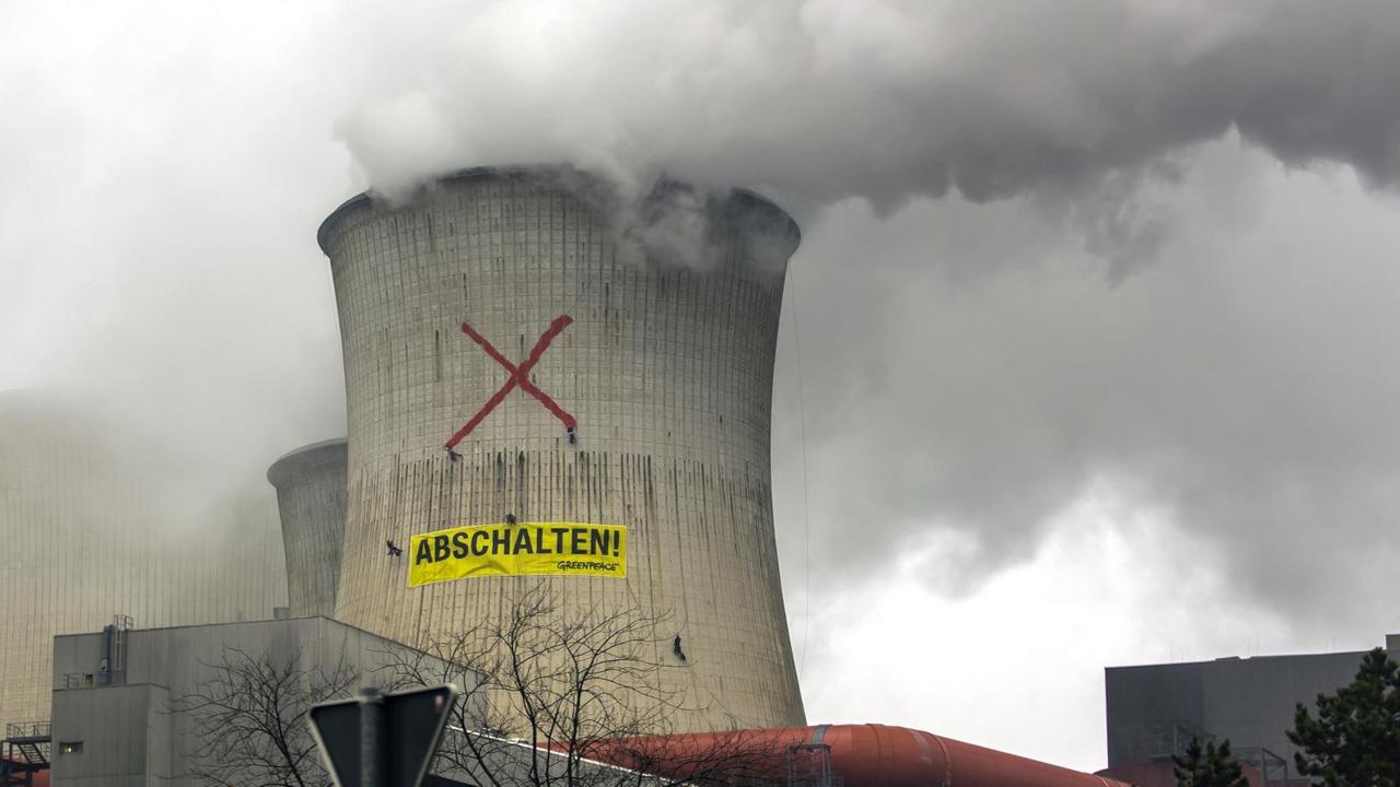 Aktivisten der Umweltschutzorganisation Greenpeace haben ein Banner mit der Aufschrift - Abschalten - an einem Turm des RWE-Braunkohlekraftwerks Neurath aufgehängt und ein rotes Kreuz aufgemalt.