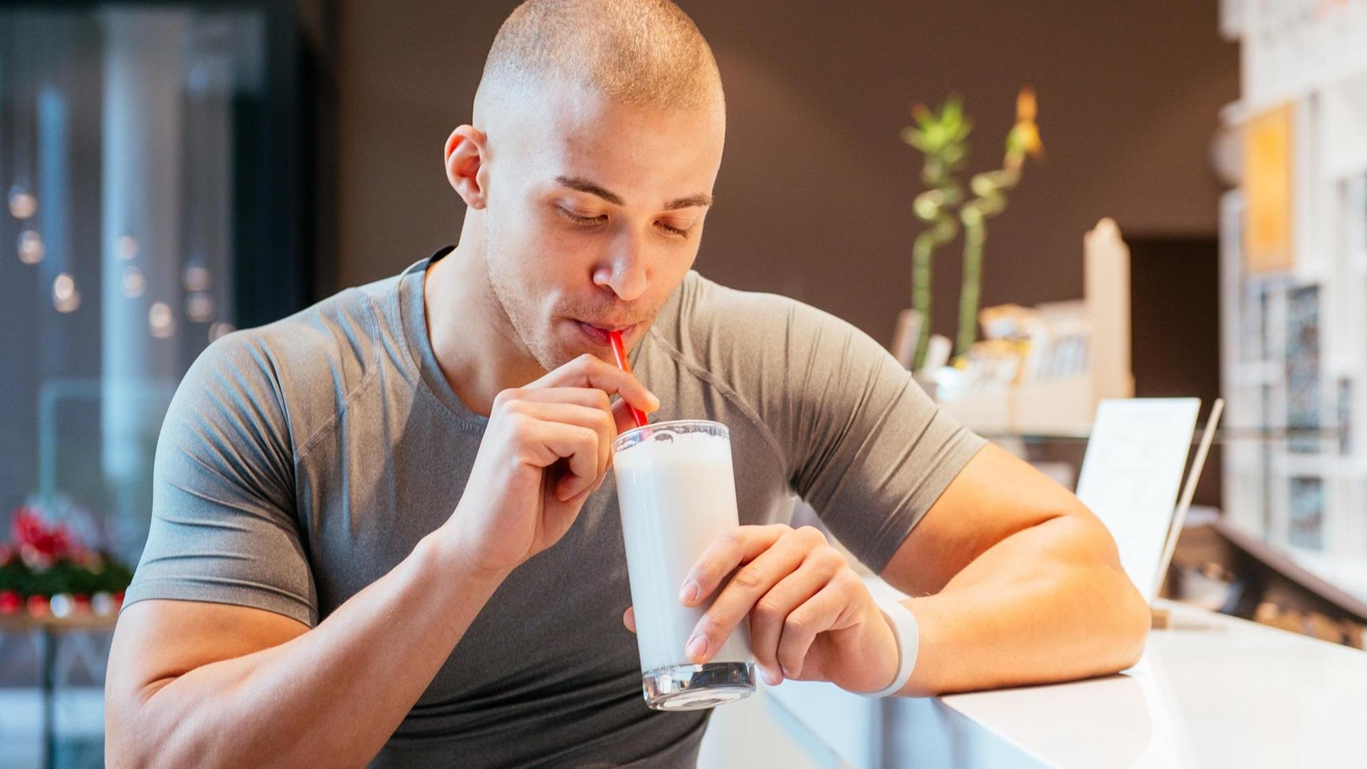 Ein junger Mann trinkt in einem Fitnessstudio einen Eiweißshake. Ein junger Mann trinkt in einem Fitnessstudio einen Eiweißshake.