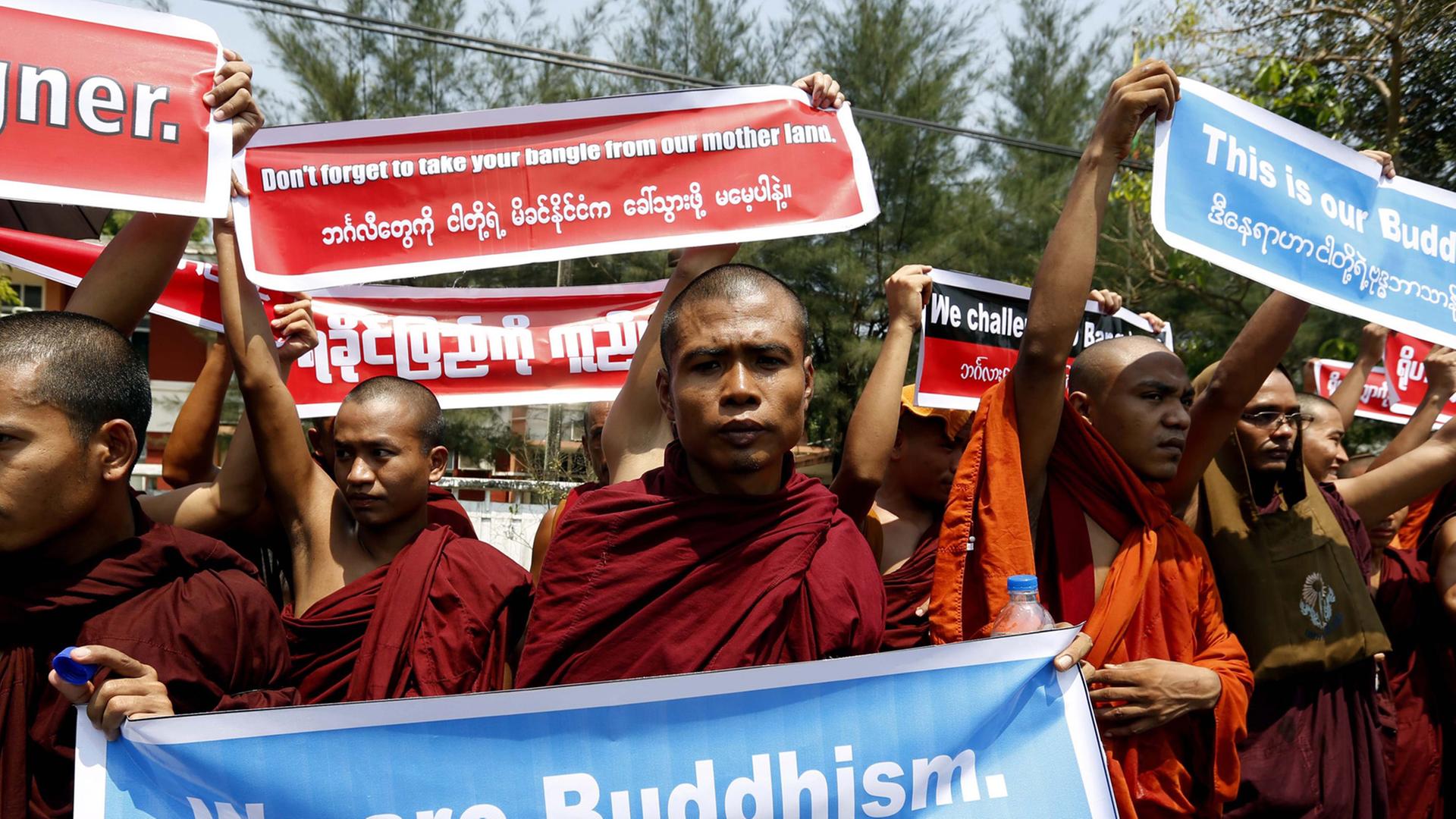 Buddhistische Mönche halten auf einer Demonstration Plakate hoch. Auf einem ist geschrieben "We ar Buddhism."