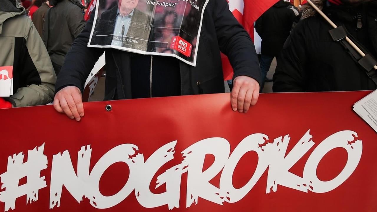 SPD-Anhänger halten am 21.01.2018 ein Schild mit der Aufschrift "#NoGroko" bei einer Demonstration vor dem WCCB beim außerordentlichen SPD-Parteitag in Bonn (Nordrhein-Westfalen). SPD-Anhänger halten am 21.01.2018 ein Schild mit der Aufschrift "#NoGroko" bei einer Demonstration vor dem WCCB beim außerordentlichen SPD-Parteitag in Bonn (Nordrhein-Westfalen).
