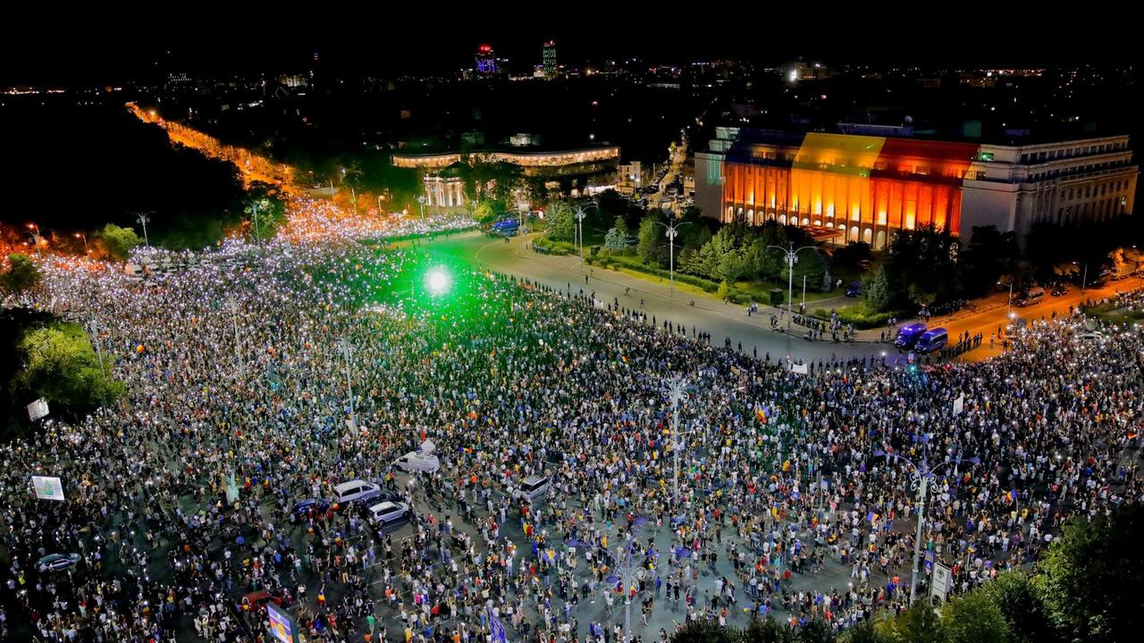 Tausende Menschen stehen auf einem Platz. Von oben ist grünes Licht zu sehen. Es sind Laserpointer der Demonstranten. Tausende Menschen stehen auf einem Platz. Von oben ist grünes Licht zu sehen. Es sind Laserpointer der Demonstranten.