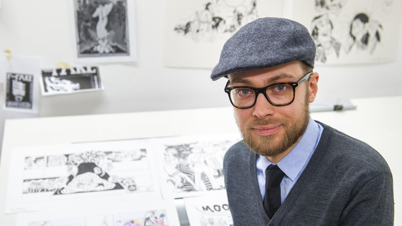 Der Comic-Zeichner Simon Schwartz sitzt in seinem Büro