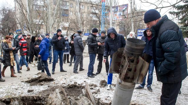 Nach dem Einschlag einer Rakete in der Stadt Kramatorsk versammeln sich viele Zivilisten um den Krater.