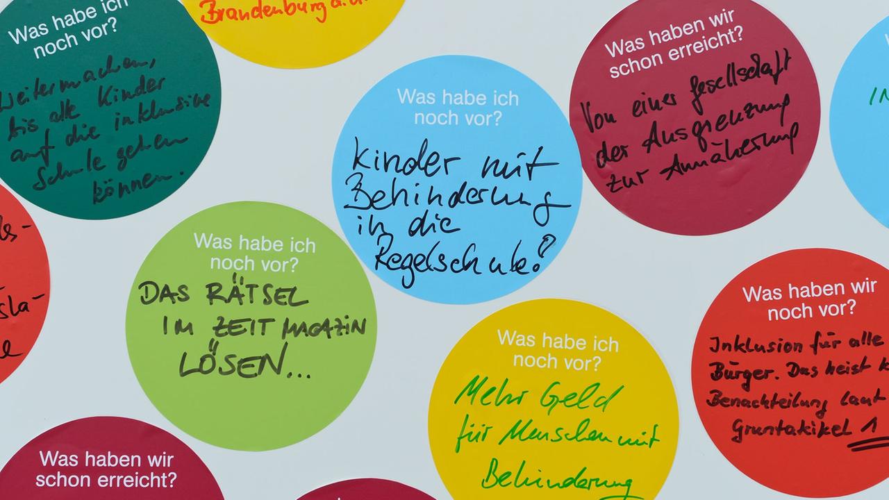 Bunte Zettel mit persönlichen Aufschriften kleben auf dem Pariser Platz in Berlin an der Wand eines Informationsstandes am Europäischen Protesttag zur Gleichstellung von Menschen mit Behinderung. Bunte Zettel mit persönlichen Aufschriften kleben auf dem Pariser Platz in Berlin an der Wand eines Informationsstandes am Europäischen Protesttag zur Gleichstellung von Menschen mit Behinderung.