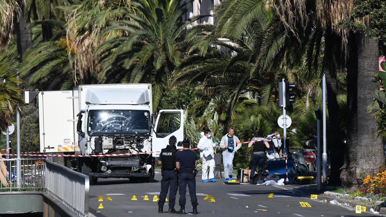 Ermittler stehen neben dem LKW in Nizza, den ein Mann Donnerstag Abend in die Menschenmenge gelenkt hat
