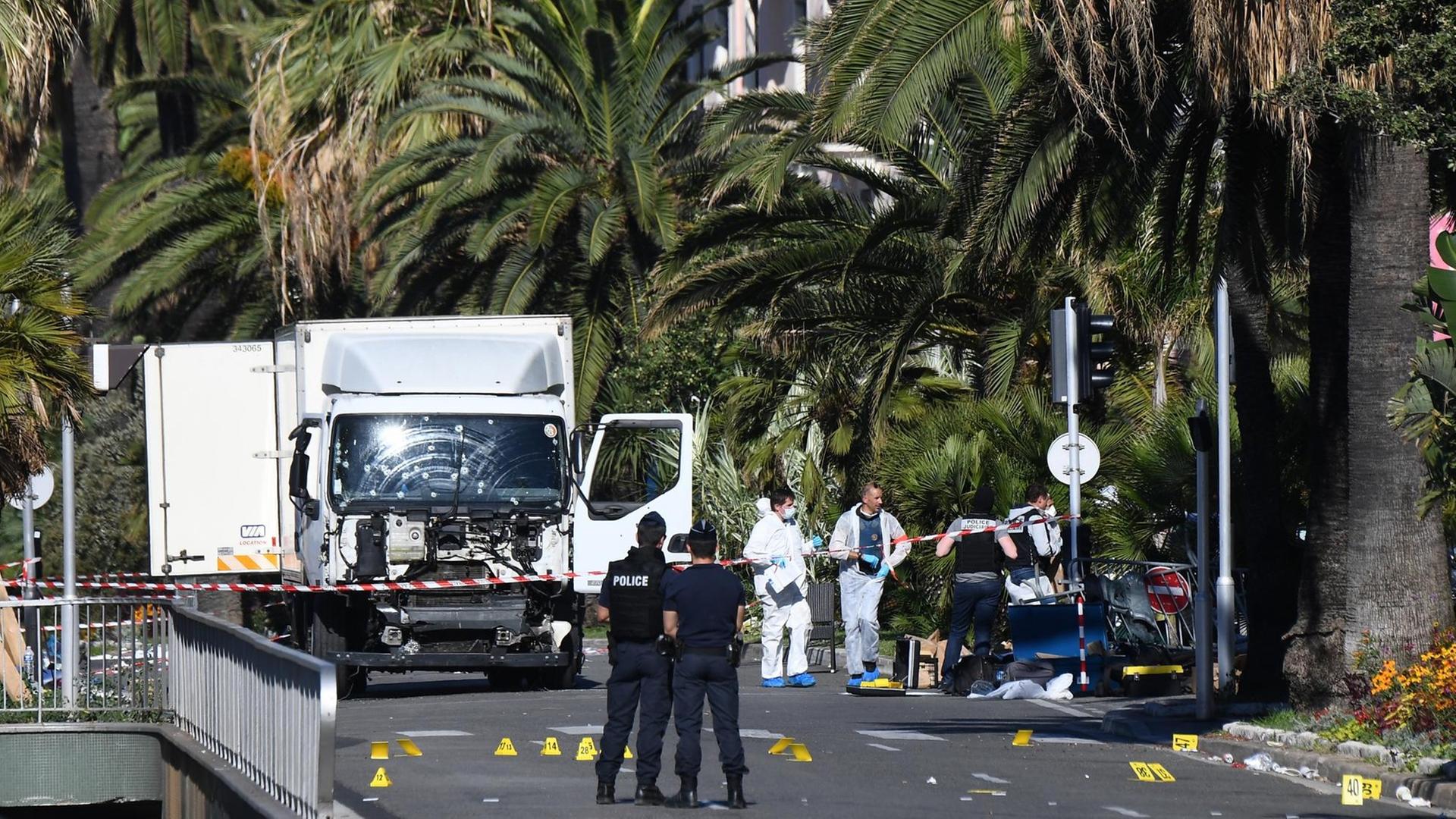 Ermittler stehen neben dem LKW in Nizza, den ein Mann Donnerstag Abend in die Menschenmenge gelenkt hat Ermittler stehen neben dem LKW in Nizza, den ein Mann Donnerstag Abend in die Menschenmenge gelenkt hat