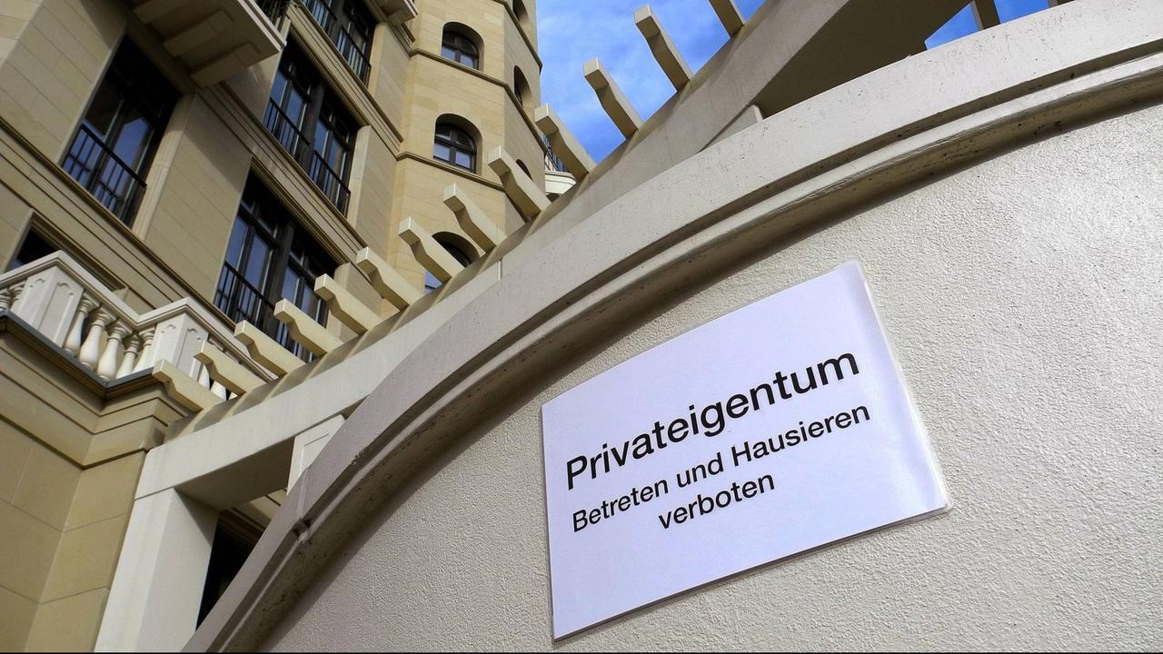 "Privateigentum - Betreten und Hausieren verboten" steht auf einem Schild vor einer Mauer der Fellini-Höfe in Berlin-Mitte.